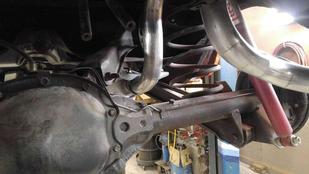 Custom exhaust tubing routed around a rear suspension
