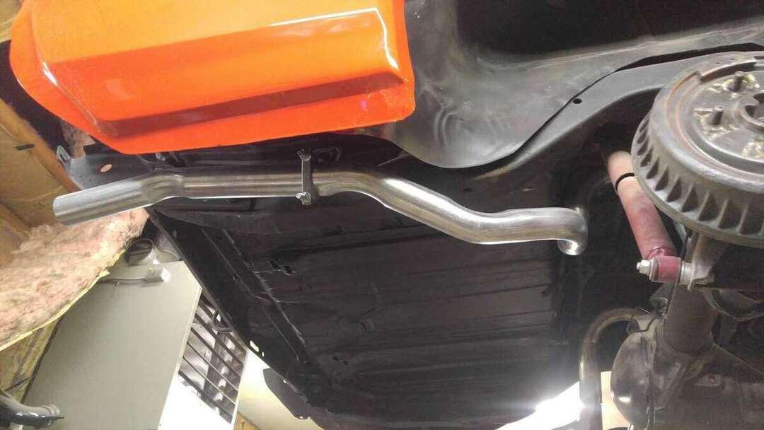 Finished curved tailpipe and hanger under a red car