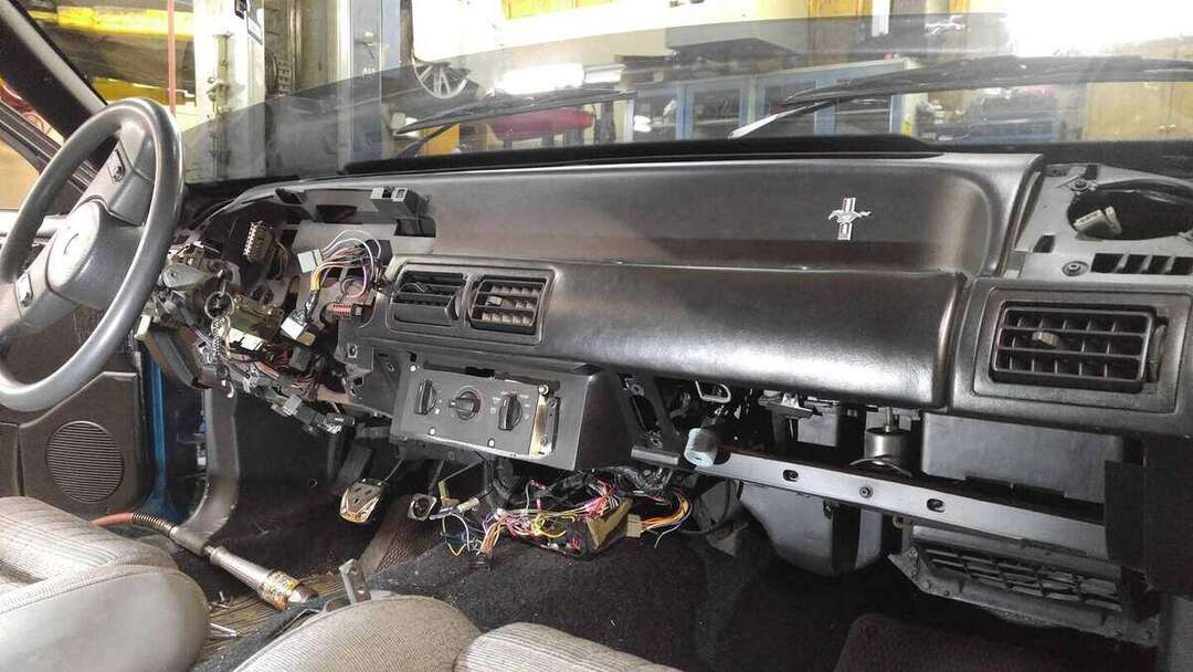 Fox-body lower dashboard opened with wiring exposed