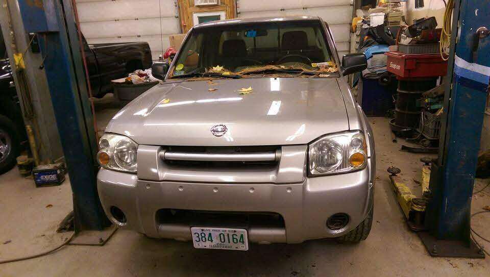 Completed silver Nissan truck after front-end repair