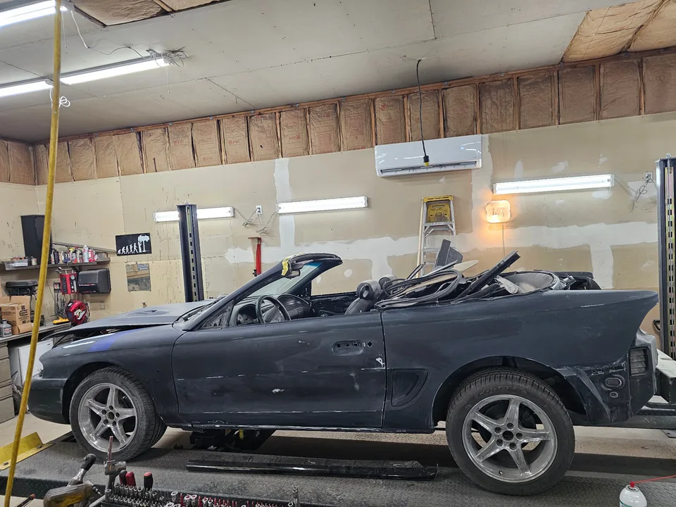 Driver-side view of the 1997 Ford Mustang GT convertible with sanded body panels and trim removed