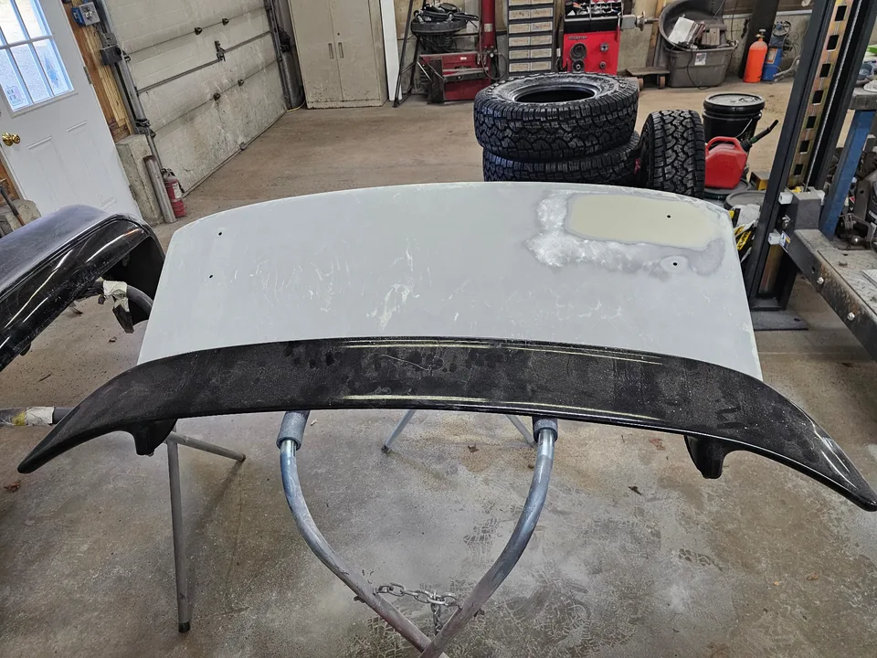 Mustang trunk lid and spoiler on a stand during paint preparation