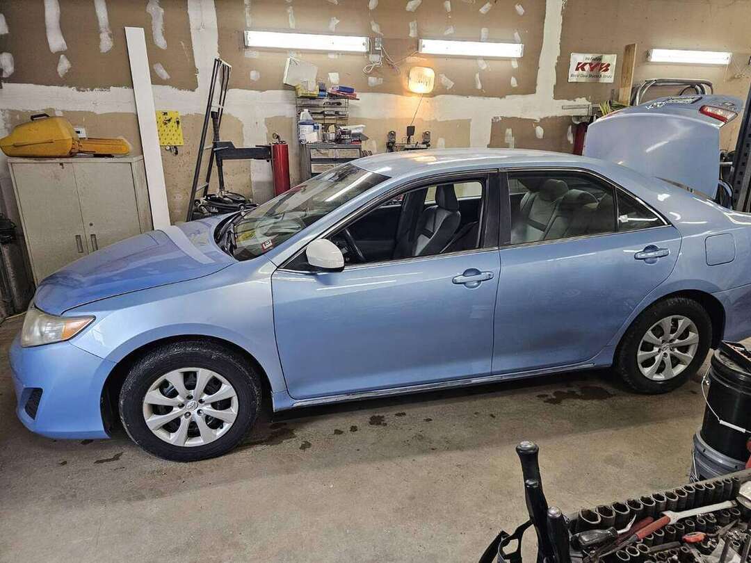 Completed blue Toyota Camry after driver-side door replacement and color-matched paint