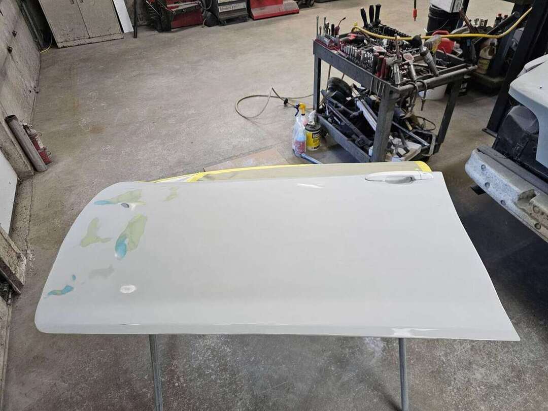 Replacement Toyota Camry door in primer during surface preparation