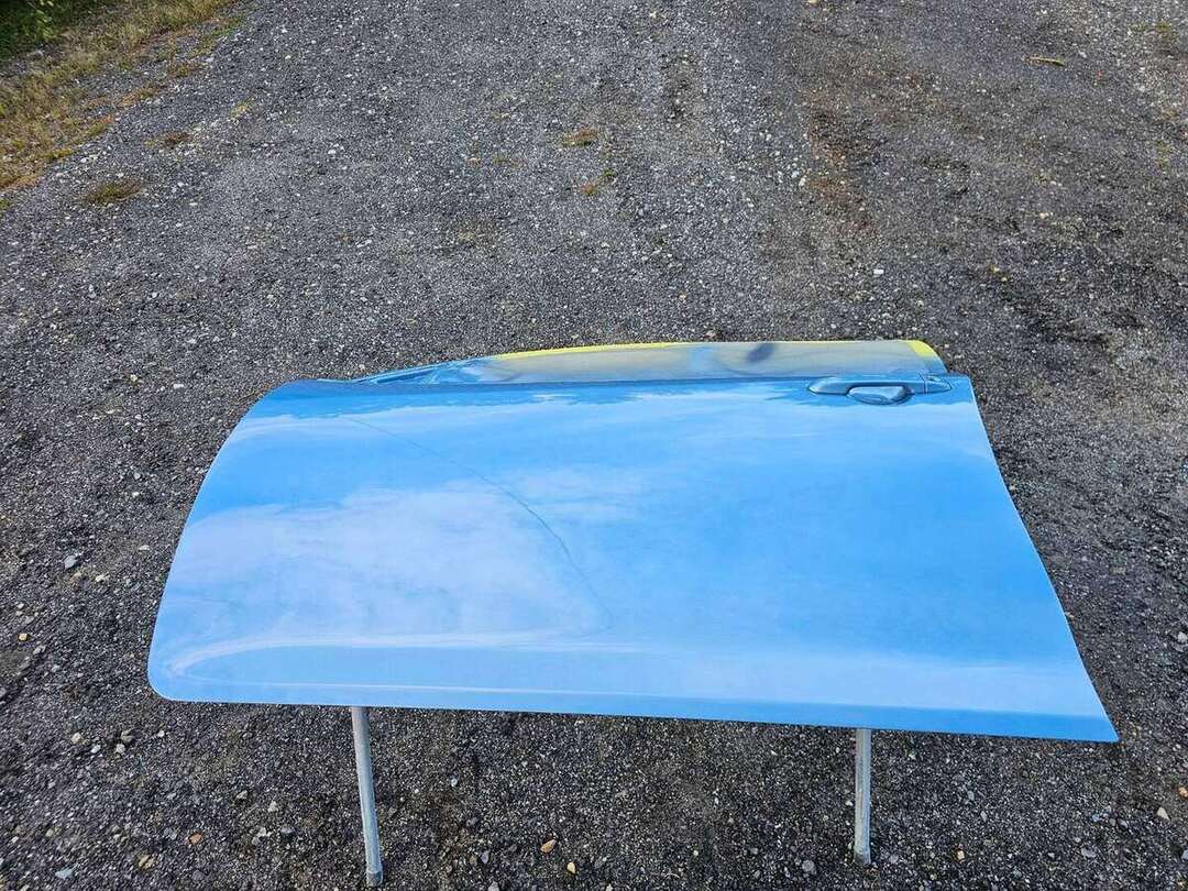 Color-matched blue Toyota Camry replacement door after painting