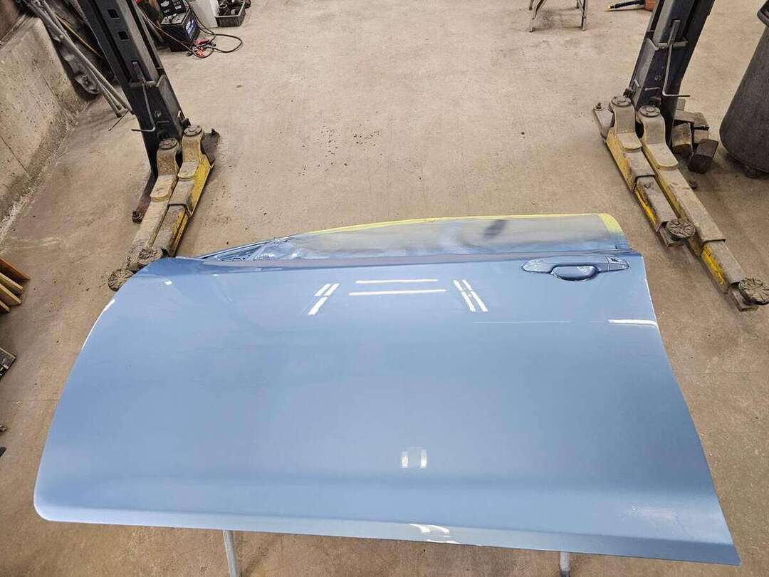 Glossy blue finish on a freshly painted Toyota Camry door