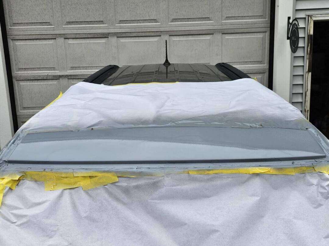 Fresh black paint on the repaired Dodge Durango roof above the windshield