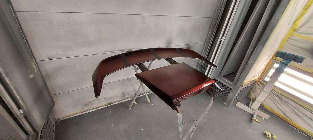 Mustang rear spoiler and trim pieces being refinished in the paint booth