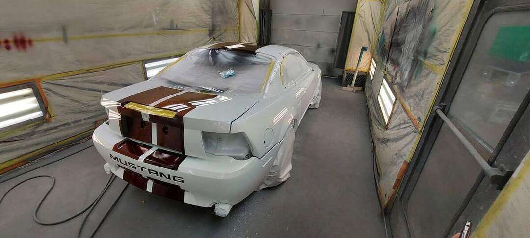 Rear bumper and deck of a Mustang GT masked during stripe painting