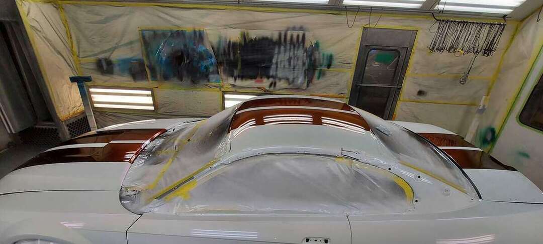 Gloss burgundy roof and deck stripes under paint-booth lights