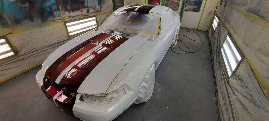 Fresh burgundy hood stripes and white paint on a Mustang GT