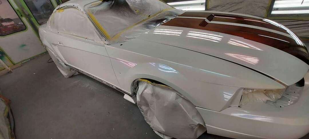 Front-quarter view of the freshly painted Mustang in the booth