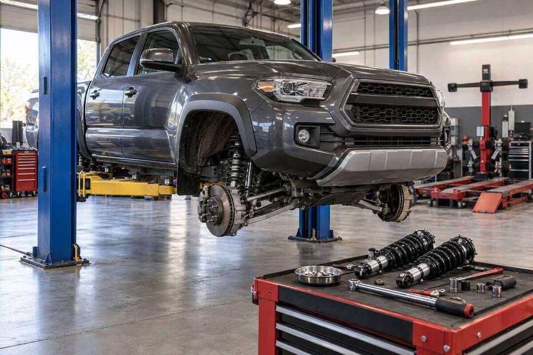 Representative midsize pickup suspension upgrade on a lift in a professional repair shop